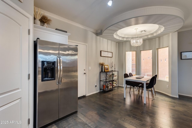 dining area featuring dark hardwood / wood-style flooring, crown molding, and a chandelier