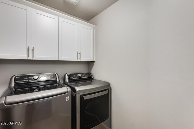 laundry room with washer and dryer and cabinets