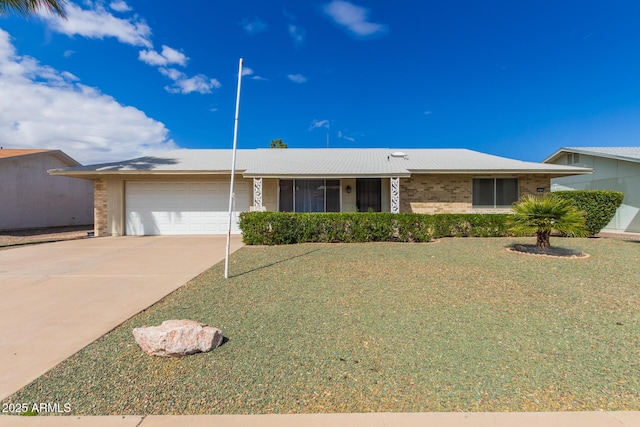 ranch-style home featuring brick siding, an attached garage, driveway, and a front yard