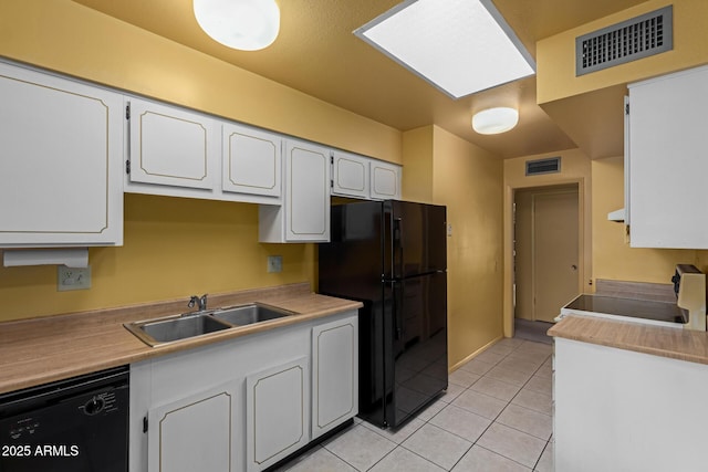 kitchen with a sink, visible vents, black appliances, and light tile patterned floors