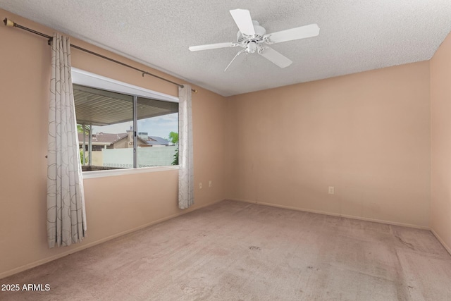 carpeted empty room with baseboards, a textured ceiling, and a ceiling fan