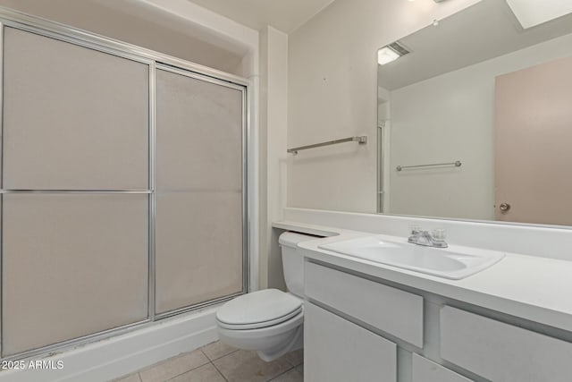 bathroom with tile patterned floors, a shower with door, toilet, and vanity