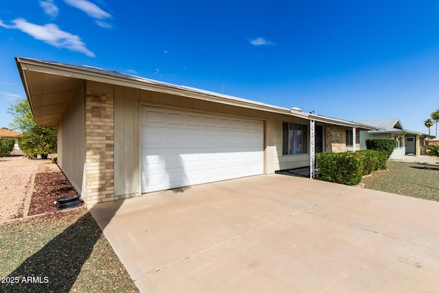 view of front of house featuring stone siding, a garage, and driveway