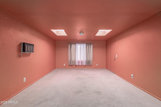 unfurnished room featuring light carpet, a skylight, and a wall mounted AC