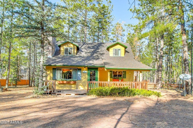 view of front of home with covered porch and fence