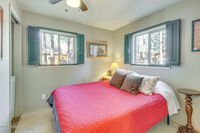 bedroom with multiple windows, carpet, a ceiling fan, and baseboards