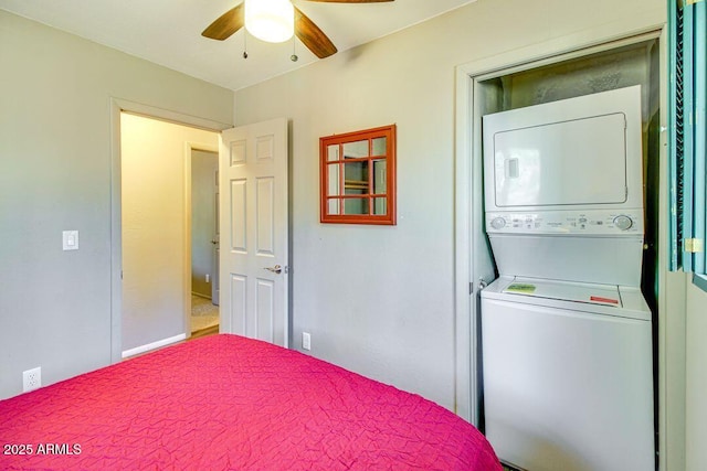 bedroom featuring a ceiling fan and stacked washer / drying machine