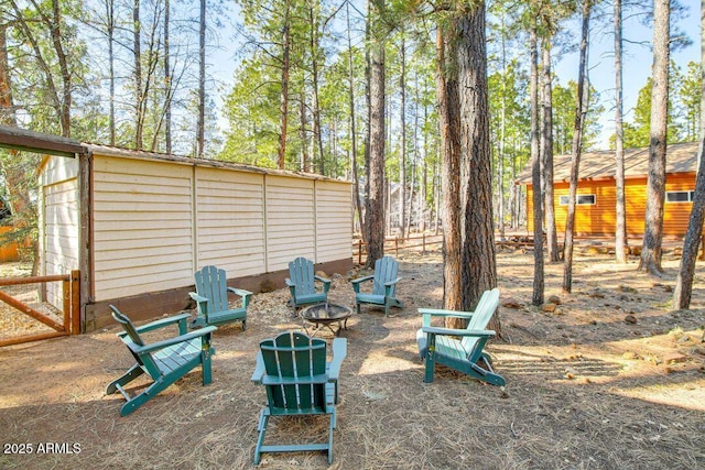 view of yard with an outdoor fire pit, an outdoor structure, and fence