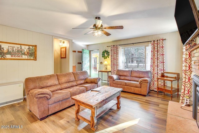 living room with light wood-style floors and a ceiling fan