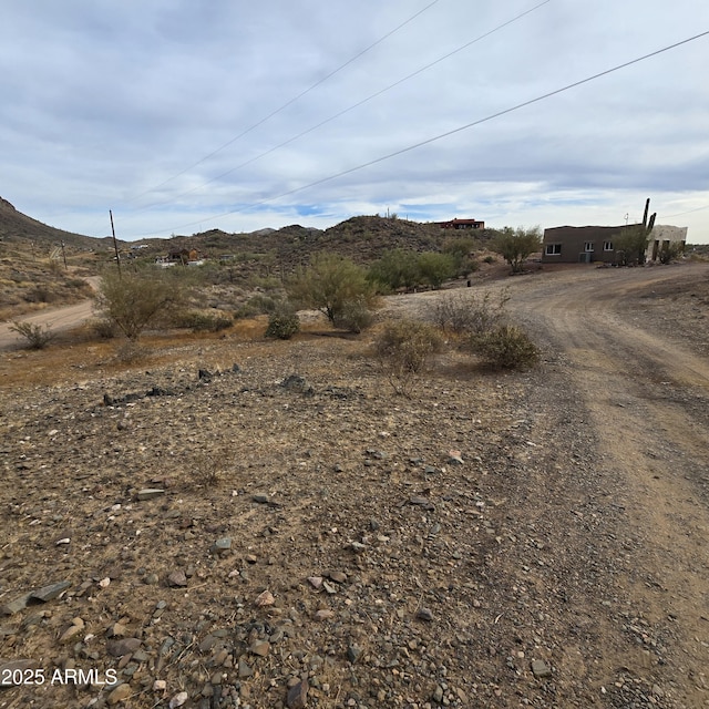 exterior space featuring dirt driveway and a mountain view