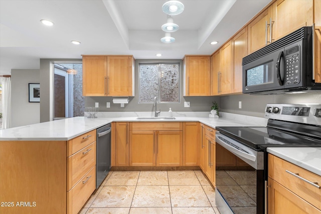 kitchen with stainless steel appliances, light countertops, a sink, and a peninsula