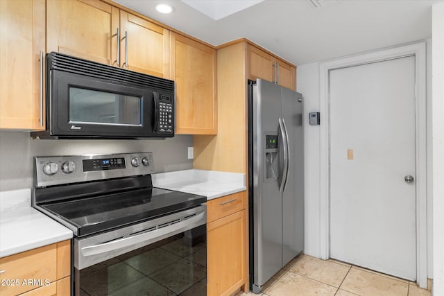 kitchen featuring light brown cabinets, stainless steel appliances, light countertops, and light tile patterned flooring