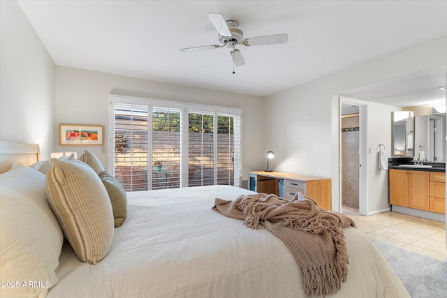 bedroom with ensuite bath, light tile patterned floors, ceiling fan, and a sink