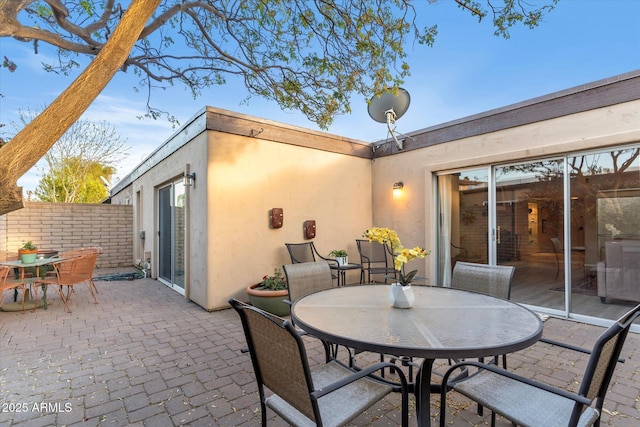 view of patio featuring outdoor dining space and fence