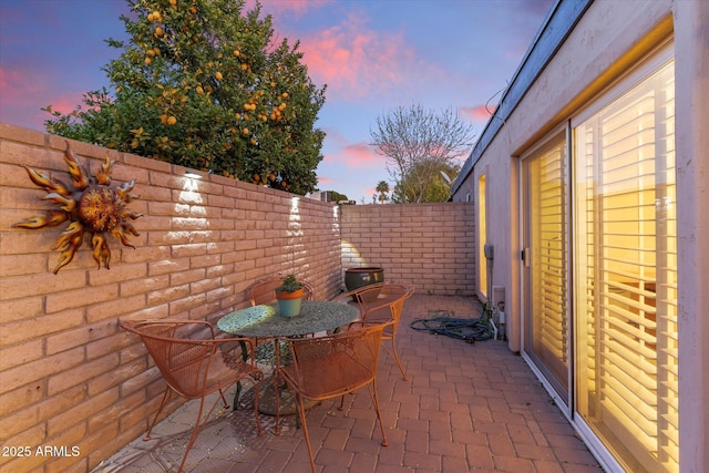 patio terrace at dusk with a fenced backyard