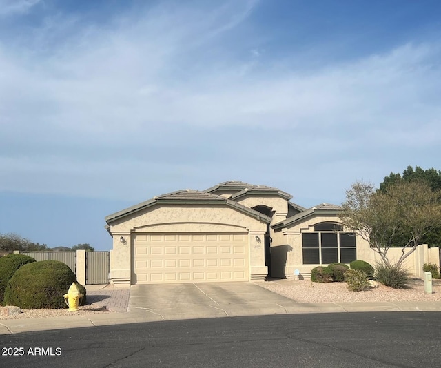 view of front of house with concrete driveway, a garage, fence, and stucco siding