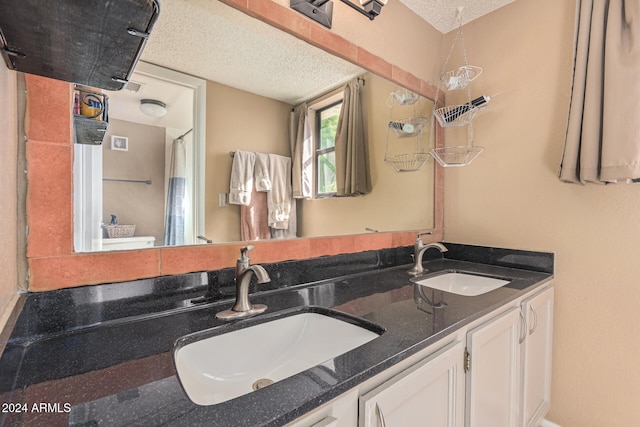 bathroom featuring vanity, a textured ceiling, and toilet