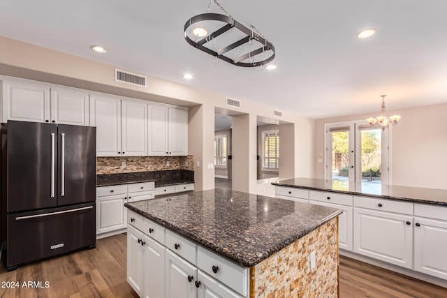 kitchen featuring white cabinets, hardwood / wood-style flooring, a center island, and stainless steel refrigerator