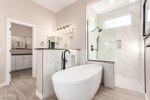 bathroom with vanity, plus walk in shower, tile walls, and hardwood / wood-style flooring