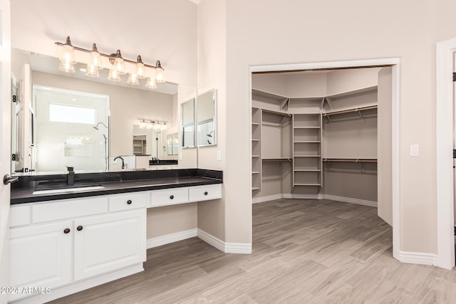 bathroom featuring hardwood / wood-style floors, vanity, and walk in shower