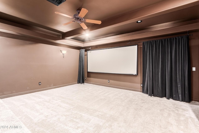 carpeted cinema room featuring beamed ceiling and ceiling fan