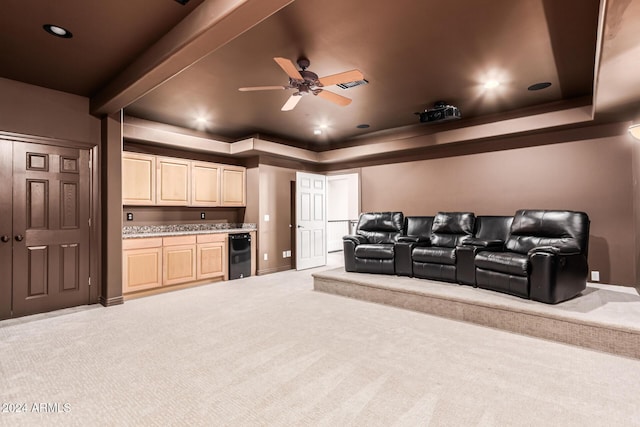 home theater featuring ceiling fan, a raised ceiling, light colored carpet, and wine cooler