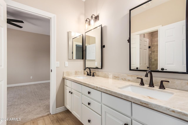 bathroom with ceiling fan, vanity, and wood-type flooring