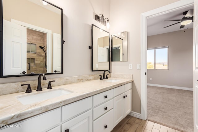 bathroom featuring hardwood / wood-style flooring, ceiling fan, tiled shower, and vanity