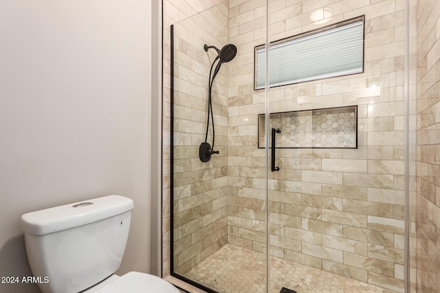 bathroom featuring toilet and an enclosed shower