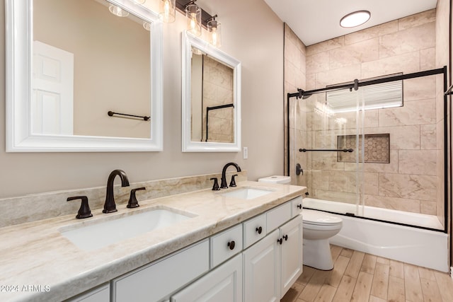 full bathroom with toilet, vanity, enclosed tub / shower combo, and hardwood / wood-style flooring