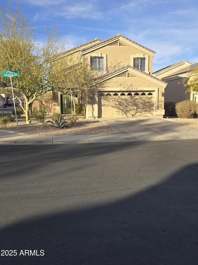 view of front of home featuring stucco siding, concrete driveway, and a tile roof