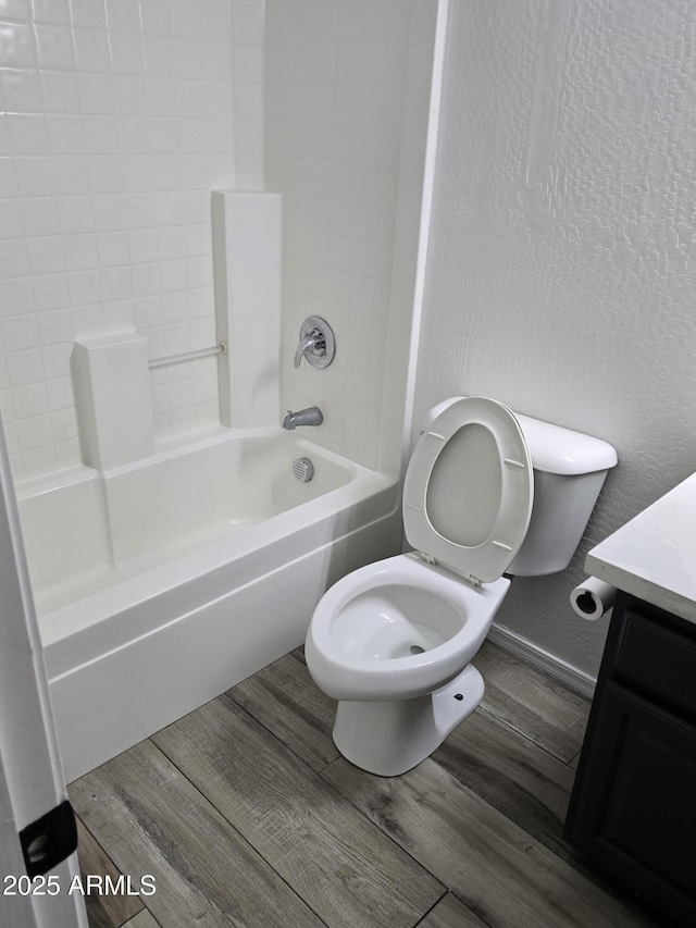 bathroom featuring vanity, toilet, wood finished floors, and shower / bathtub combination