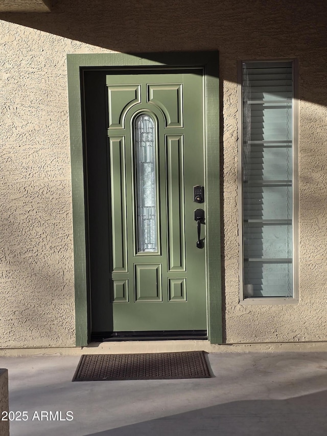 entrance to property featuring stucco siding