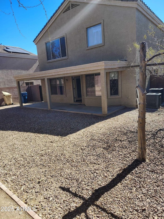 rear view of property featuring a patio, central AC unit, and stucco siding