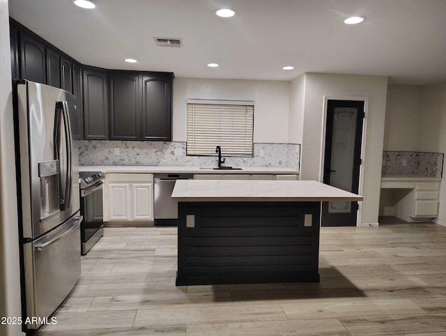 kitchen with visible vents, appliances with stainless steel finishes, light wood-type flooring, and a sink