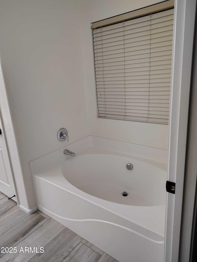 full bathroom with wood finished floors and a bath