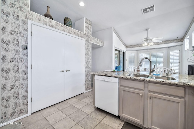 kitchen featuring vaulted ceiling, sink, light stone counters, ceiling fan, and white dishwasher