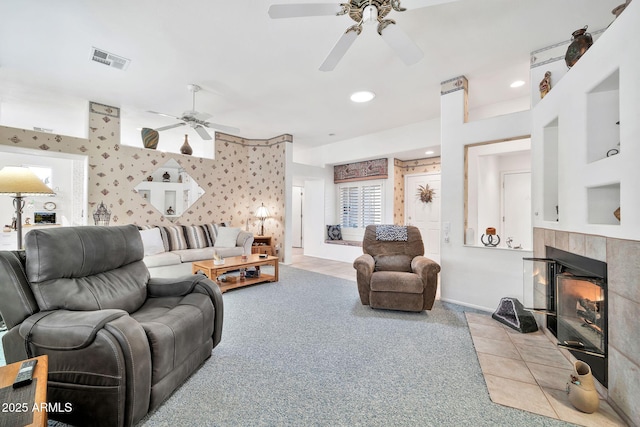 carpeted living room featuring a fireplace and ceiling fan