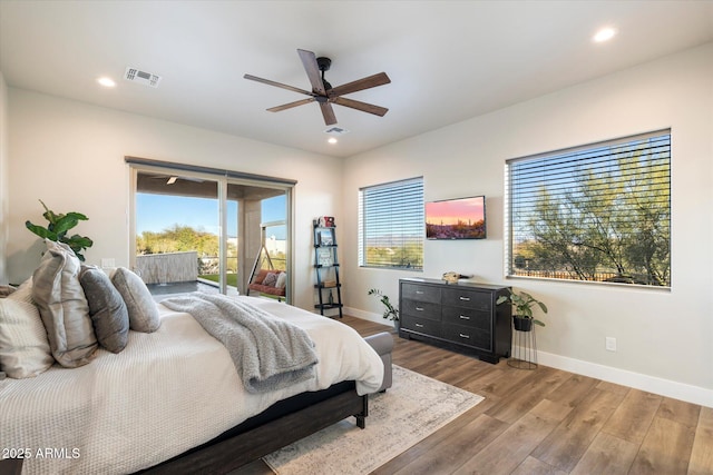 bedroom with ceiling fan, access to exterior, hardwood / wood-style floors, and multiple windows