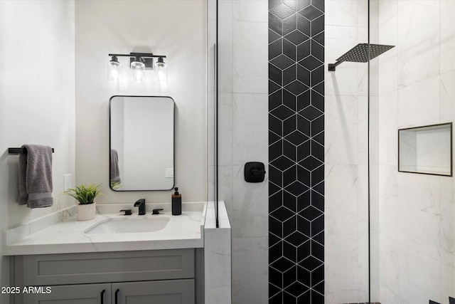 bathroom with tiled shower and vanity