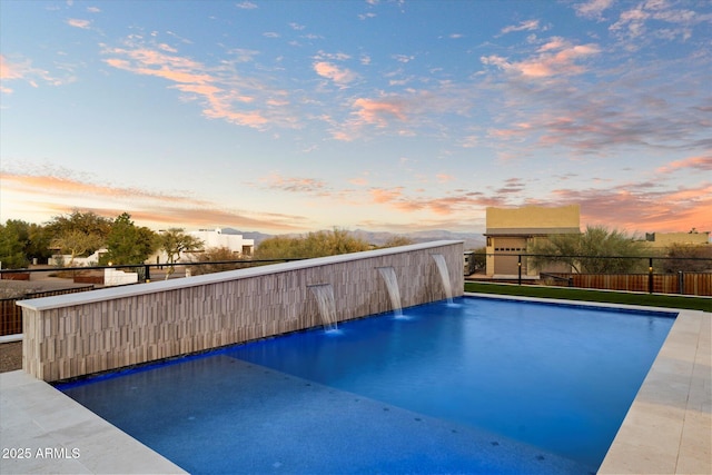 pool at dusk with pool water feature