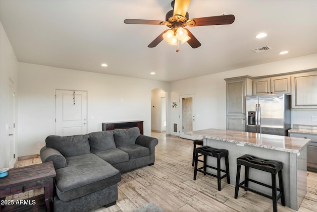 living room with light hardwood / wood-style floors and ceiling fan