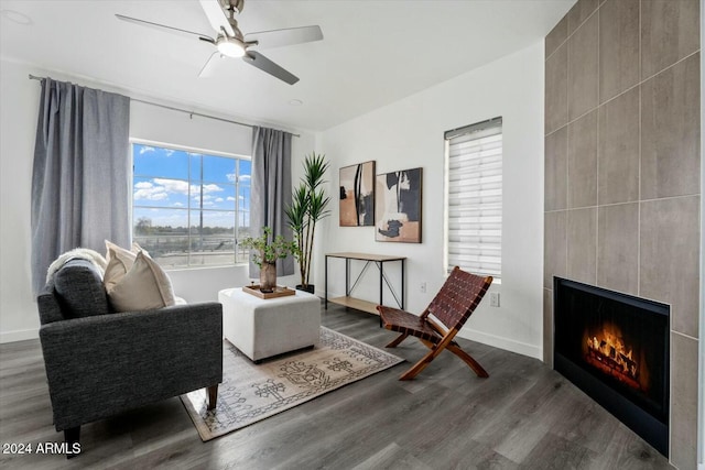 sitting room featuring ceiling fan, a fireplace, and hardwood / wood-style floors