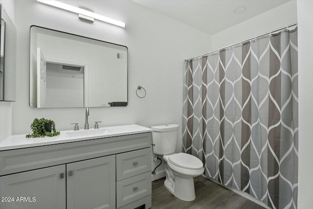 bathroom featuring a shower with shower curtain, vanity, hardwood / wood-style flooring, and toilet