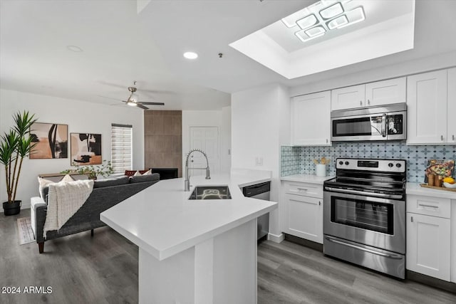 kitchen with decorative backsplash, stainless steel appliances, ceiling fan, sink, and white cabinets