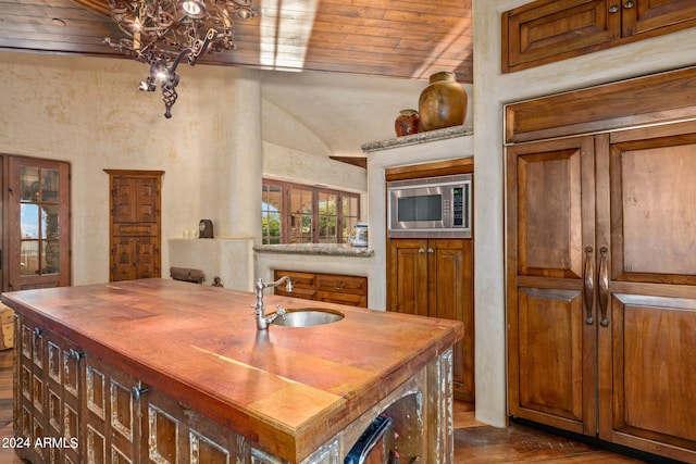 dining area featuring sink, a chandelier, wooden ceiling, dark wood-type flooring, and lofted ceiling