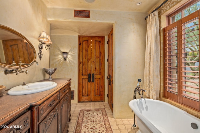 bathroom featuring vanity, tile flooring, and a tub