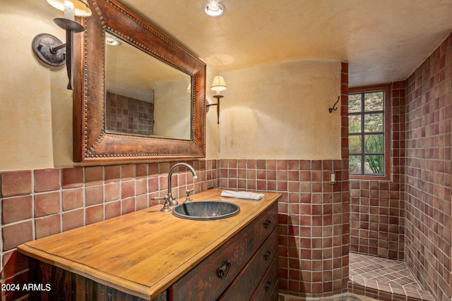 bathroom featuring backsplash, tile walls, a tile shower, and vanity