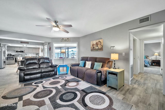 living room with ceiling fan and light hardwood / wood-style floors