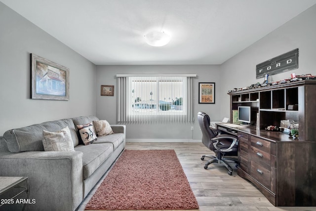 home office with light hardwood / wood-style flooring